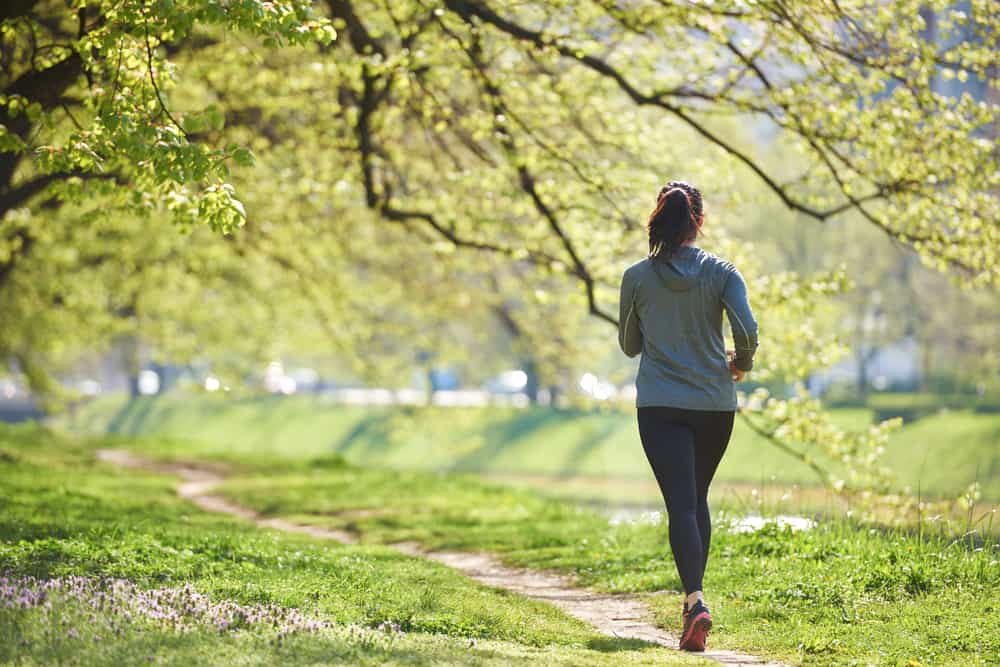 2020 young woman jogging in city park at early morning